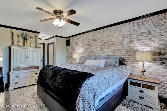 bedroom with ornamental molding, brick wall, ceiling fan, and light hardwood / wood-style flooring