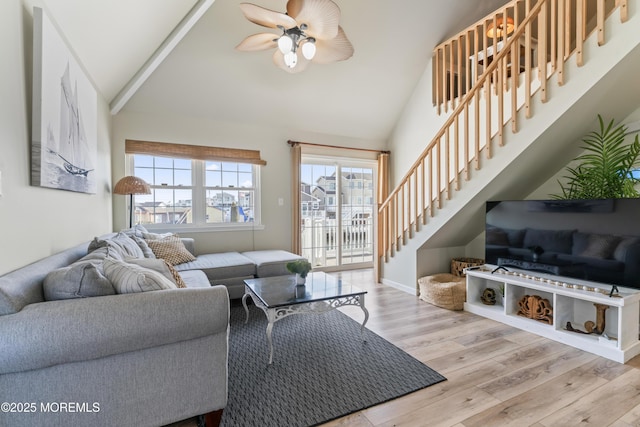 living room featuring high vaulted ceiling, ceiling fan, and light wood-type flooring