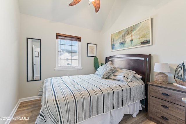 bedroom featuring dark wood-type flooring, vaulted ceiling, and ceiling fan