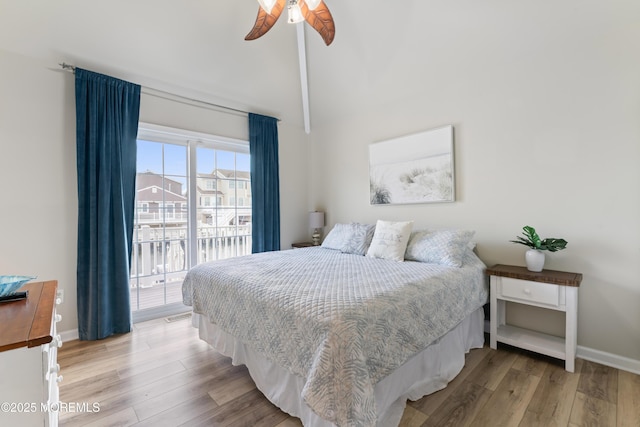 bedroom featuring access to exterior, light hardwood / wood-style floors, high vaulted ceiling, and ceiling fan