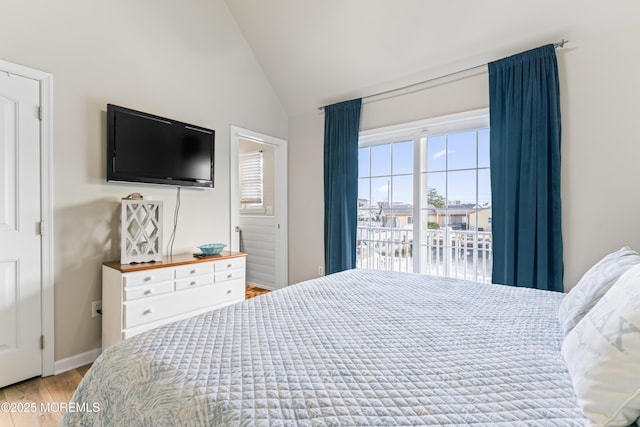 bedroom with lofted ceiling and light hardwood / wood-style floors