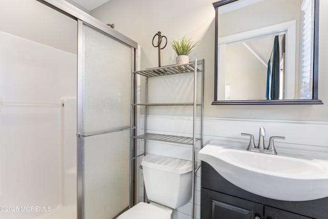 bathroom with vanity, toilet, and a shower with shower door