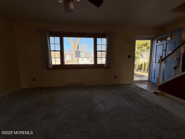 carpeted spare room with ceiling fan