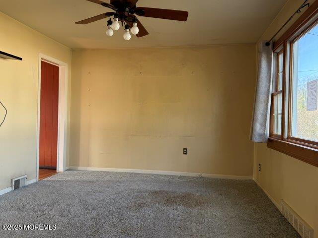 carpeted spare room featuring ceiling fan