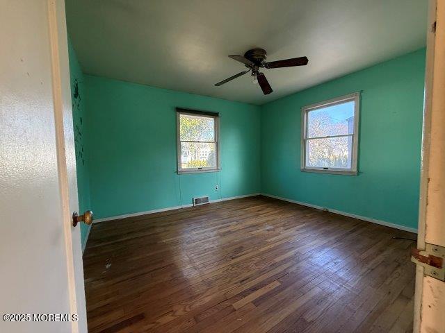 spare room featuring dark wood-type flooring and ceiling fan