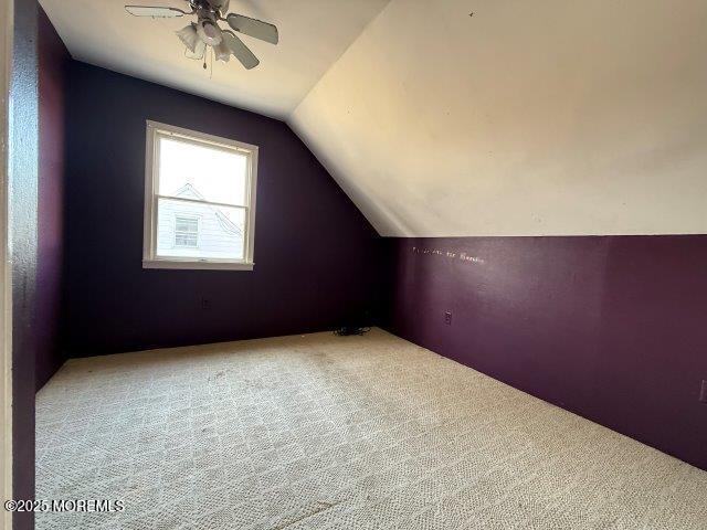 bonus room with lofted ceiling, carpet flooring, and ceiling fan