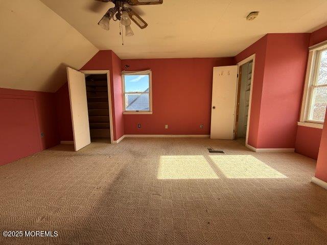 additional living space featuring light carpet, vaulted ceiling, and ceiling fan