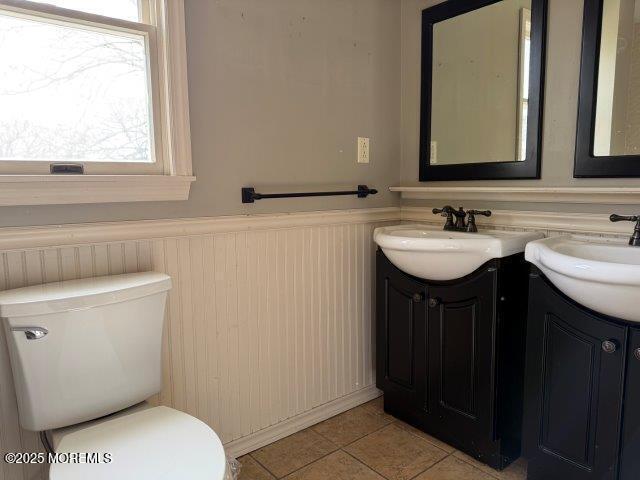 bathroom with tile patterned flooring, vanity, plenty of natural light, and toilet