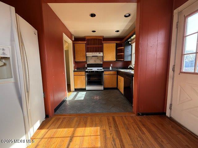 kitchen featuring sink, white appliances, and light wood-type flooring