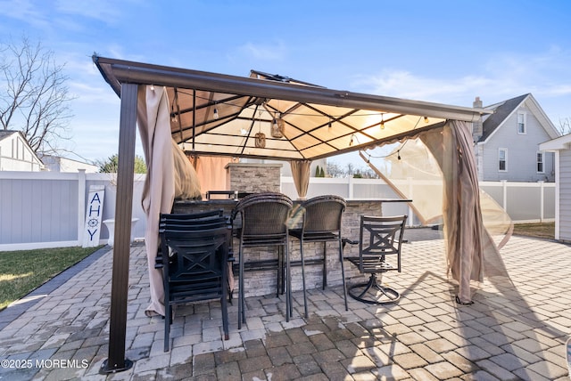 view of patio / terrace featuring a gazebo and an outdoor bar