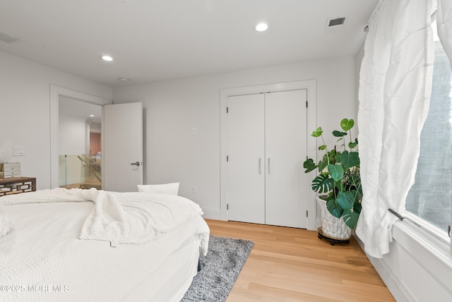 bedroom with hardwood / wood-style floors and a closet