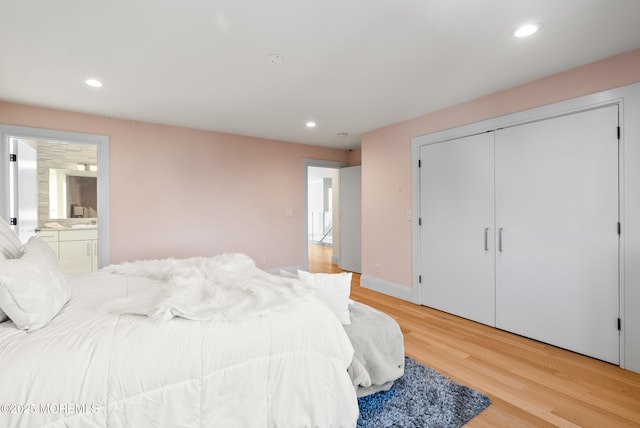 bedroom featuring ensuite bath and light hardwood / wood-style flooring