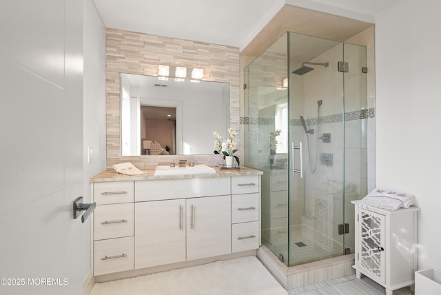 bathroom featuring vanity and a shower with door