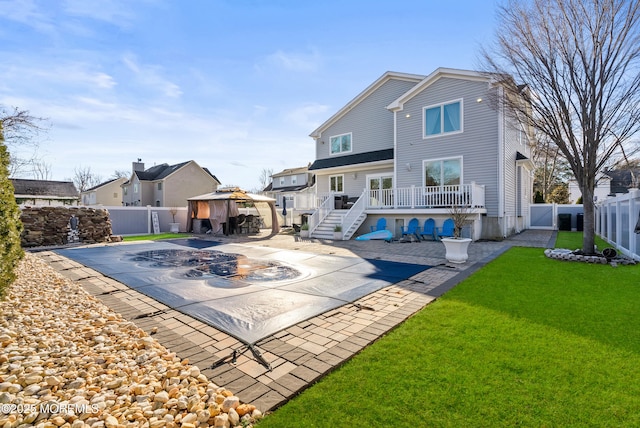 back of house featuring a yard, a gazebo, a patio area, and a covered pool