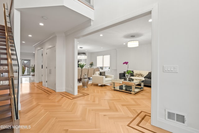 hall with ornamental molding and light parquet floors