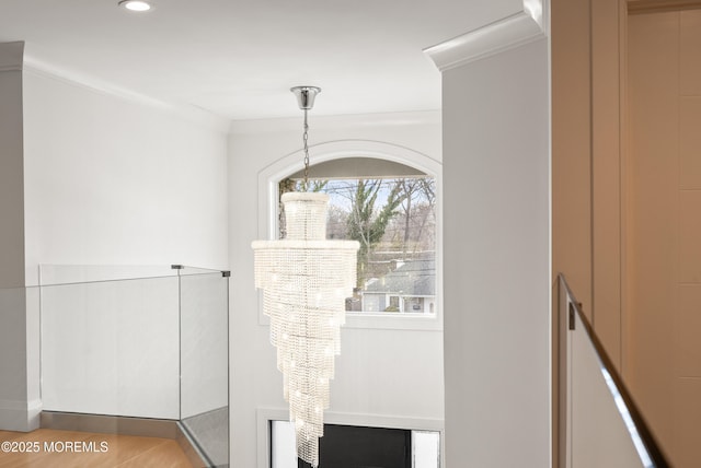 interior details with a notable chandelier, hardwood / wood-style flooring, and ornamental molding