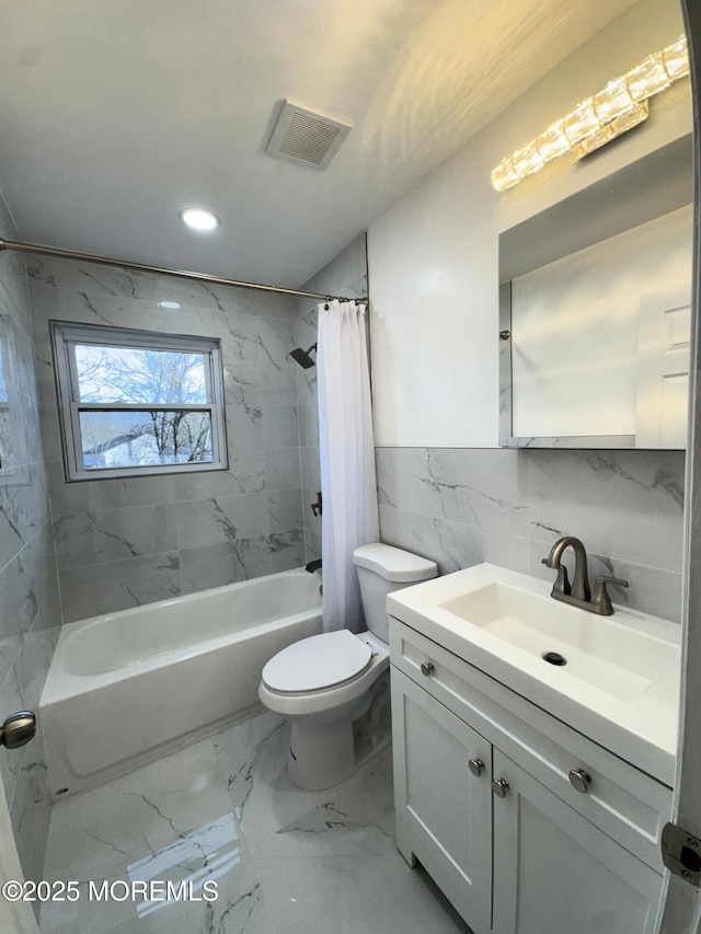 full bathroom with shower / bath combination with curtain, vanity, toilet, and tile walls