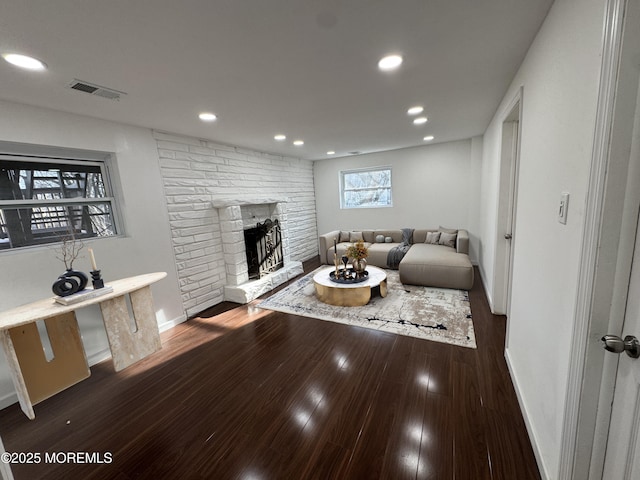 living room with dark wood-type flooring and a fireplace