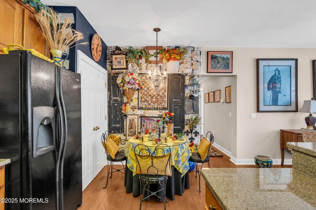 93 Golden Eye Ln, Port Monmouth, NJ 07758 - kitchen with baseboards, light wood-type flooring, light stone counters, black fridge, and brown cabinets