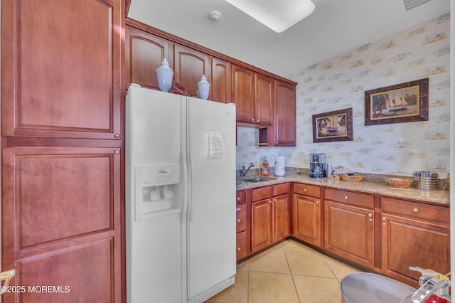 93 Golden Eye Ln, Port Monmouth, NJ 07758 - kitchen with light tile patterned floors, white fridge with ice dispenser, light stone countertops, a sink, and wallpapered walls