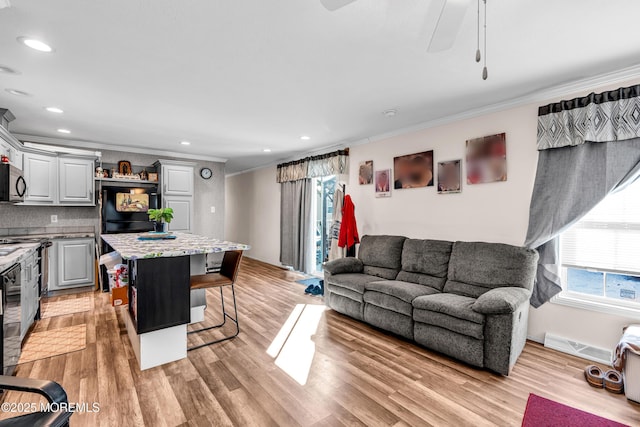 living room with crown molding and light wood-type flooring