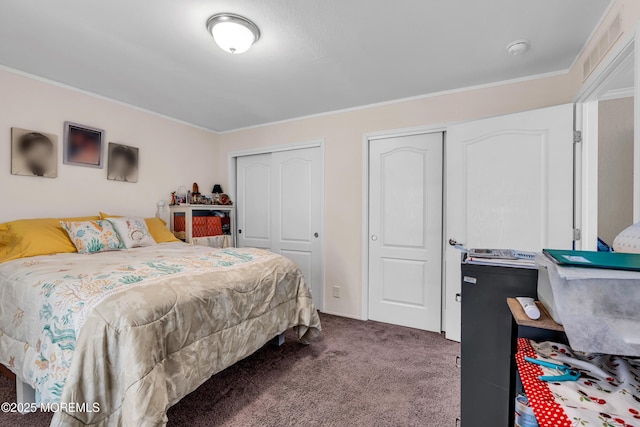 bedroom featuring two closets, carpet floors, and ornamental molding