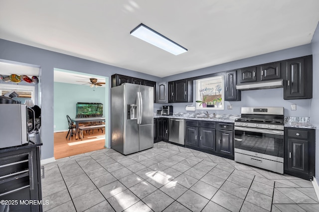 kitchen featuring wine cooler, sink, light stone counters, ceiling fan, and stainless steel appliances