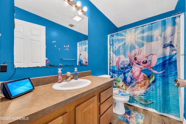 bathroom featuring wood-type flooring, toilet, a shower with shower curtain, and vanity