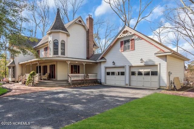 victorian house featuring a garage and covered porch