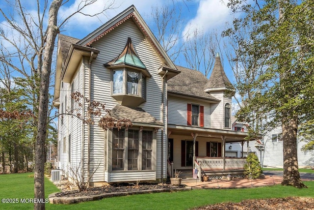 victorian home featuring central AC, a front lawn, and a porch