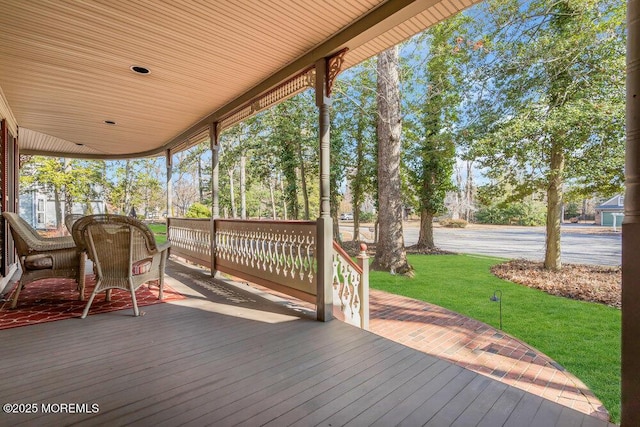 wooden terrace featuring a lawn