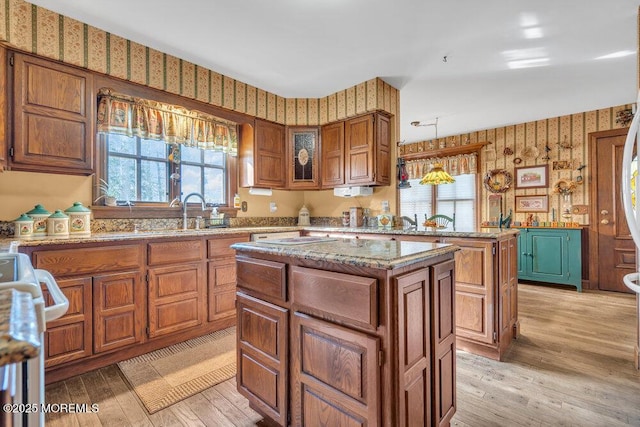 kitchen featuring plenty of natural light, light hardwood / wood-style floors, sink, and a kitchen island