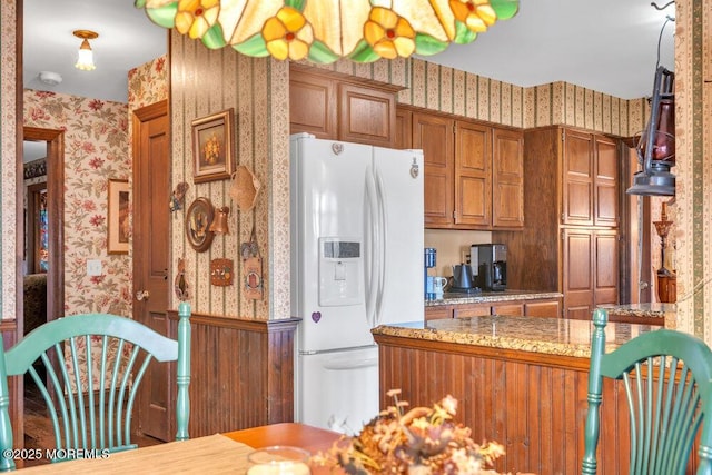 kitchen with white refrigerator with ice dispenser and kitchen peninsula