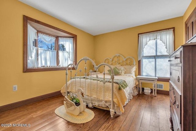 bedroom with multiple windows and light hardwood / wood-style flooring