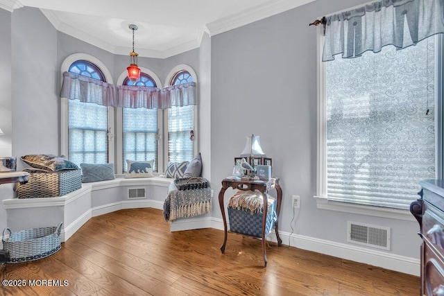 sitting room with hardwood / wood-style floors and ornamental molding