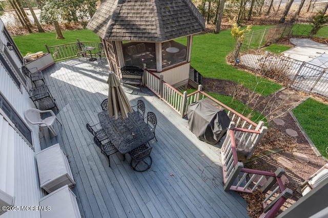 wooden deck featuring area for grilling, a gazebo, and a lawn