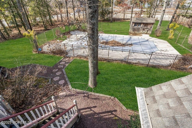 view of yard with a community pool, a patio area, and a storage shed