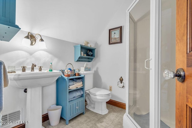 bathroom with a shower with shower door, toilet, and vaulted ceiling