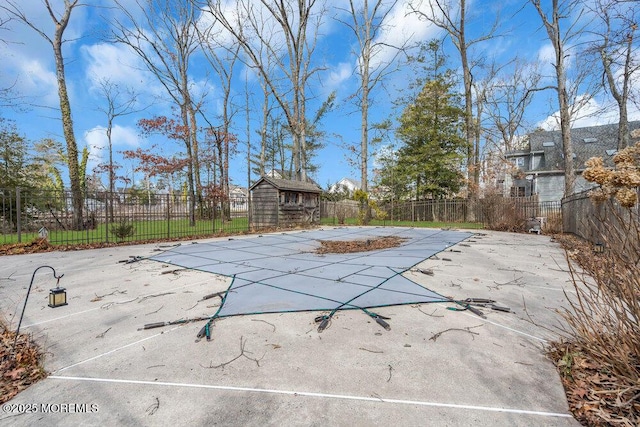 view of pool with a storage shed and a patio area