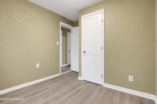 unfurnished bedroom featuring a closet and light hardwood / wood-style floors