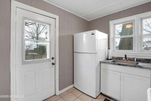 kitchen featuring sink, white cabinets, white refrigerator, and a wealth of natural light