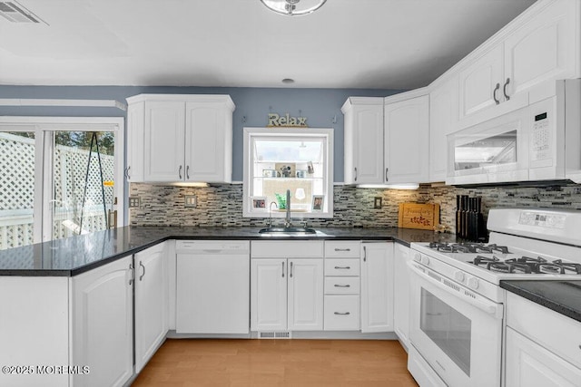 kitchen featuring sink, white appliances, and white cabinets