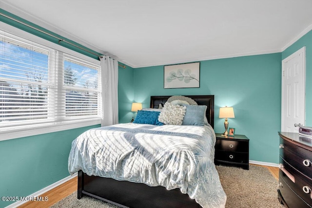 bedroom featuring ornamental molding and light wood-type flooring