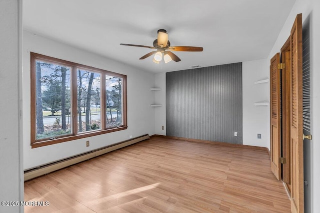 unfurnished bedroom featuring ceiling fan, light hardwood / wood-style floors, and a baseboard heating unit