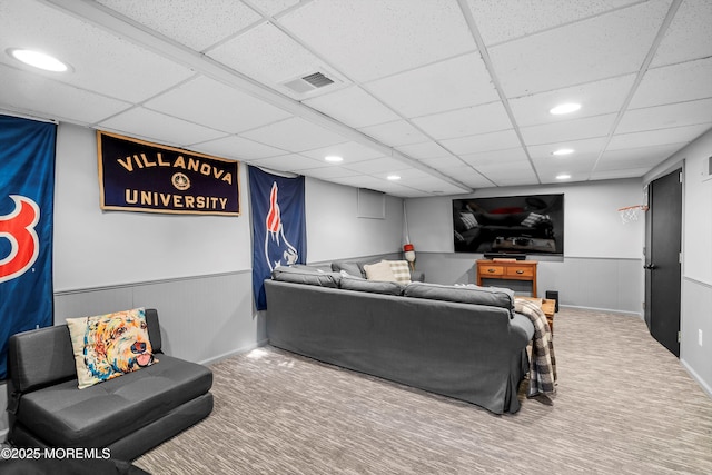 carpeted living room featuring a drop ceiling