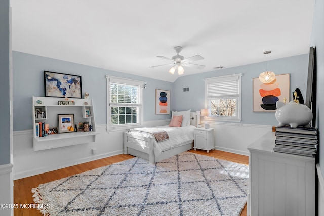 bedroom with multiple windows, light hardwood / wood-style floors, and ceiling fan