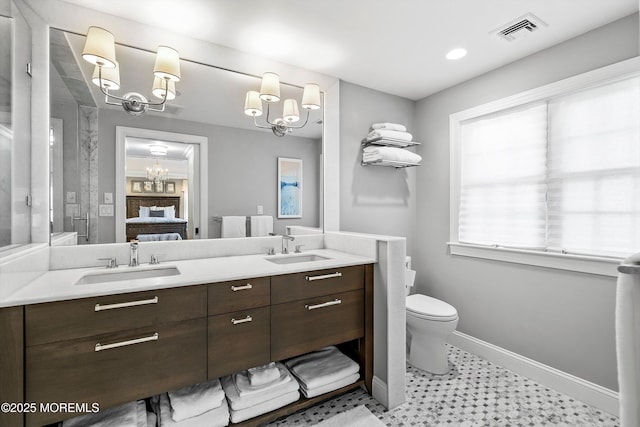 bathroom with vanity, a chandelier, and toilet