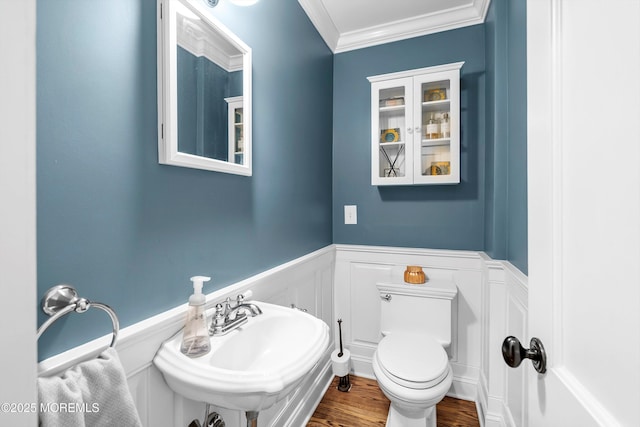 bathroom featuring ornamental molding, toilet, sink, and hardwood / wood-style floors