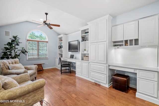 office area with ceiling fan, lofted ceiling, built in desk, and light hardwood / wood-style floors