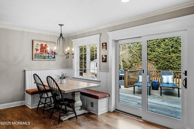 dining area featuring breakfast area, crown molding, dark hardwood / wood-style floors, and an inviting chandelier